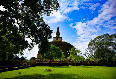 Traditional building by trees against sky