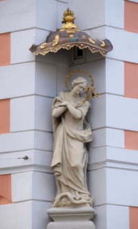 Statue against wall of building