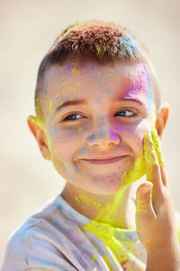 Boy applying powder paint on face