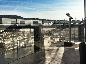 Buildings against sky seen through glass window