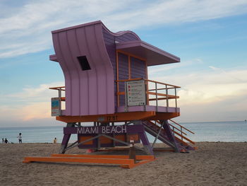 Lifeguard hut on beach against sky