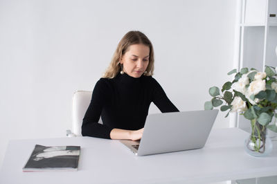 Young woman using laptop at home