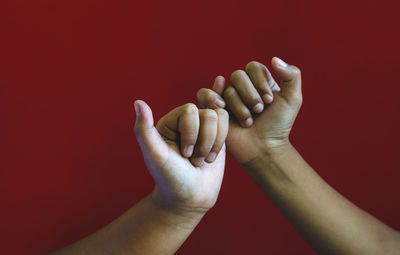 Close-up of man hand against red background