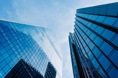 Directly below shot of glass skyscrapers against sky