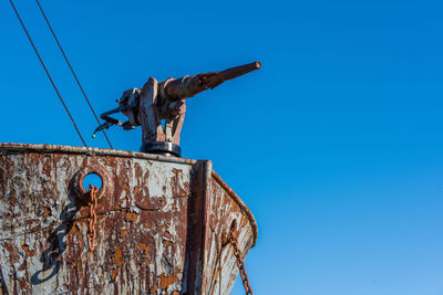 Low angle view of abandoned ship against clear blue sky