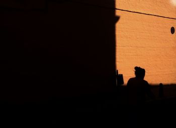Rear view of silhouette man standing in dark room