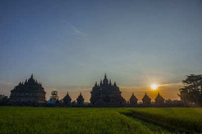 Panoramic view of temple on field against sky during sunset