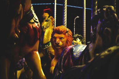 Horse and lion statues at amusement park during night