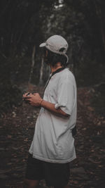 Rear view of man standing on field in forest