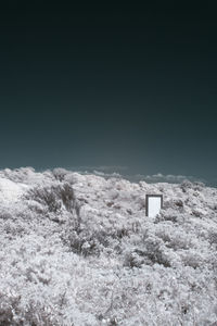 Scenic view of snow covered land against clear sky