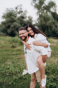 Portrait of young couple standing on field