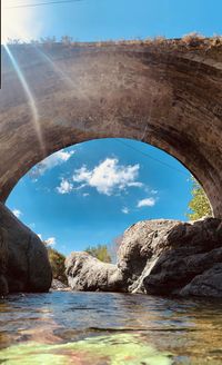 Arch bridge over sea against sky