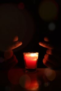 Close-up of lit candle in the dark