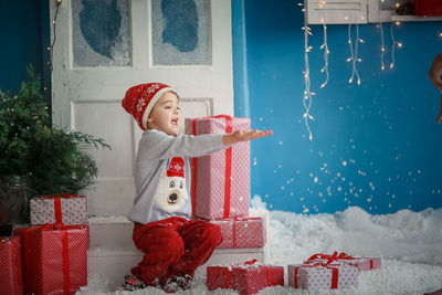 Portrait of smiling young woman with arms outstretched standing on snow