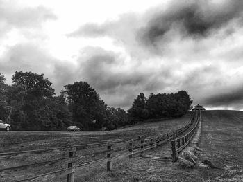 Road passing through landscape against cloudy sky