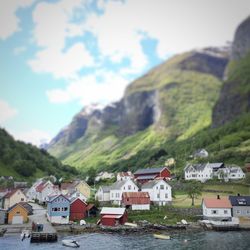 River by houses and mountains against sky