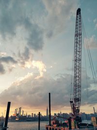 Cranes in city against sky