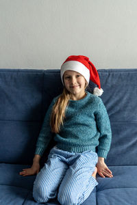 Portrait of smiling girl sitting on sofa