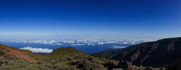 Scenic view of mountains against blue sky