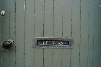 Close-up of information sign on metal door