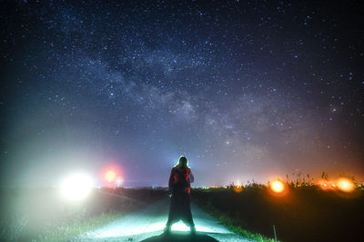 Man standing on field against sky at night