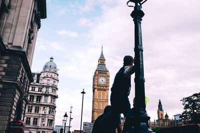 Men against big ben in city against sky