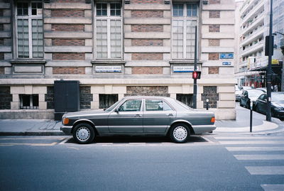 Car on street against buildings in city