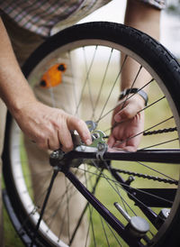 Close-up of hands repairing bicycle wheels
