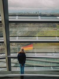 Rear view of woman standing on metal structure