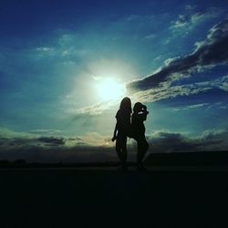 Silhouette of woman standing on landscape against sky