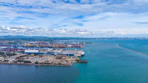 High angle view commercial dock of sea and cityscape against sky