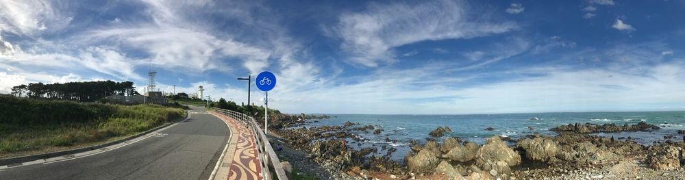 Panoramic view of road by sea against sky