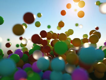 Low angle view of multi colored balloons against sky