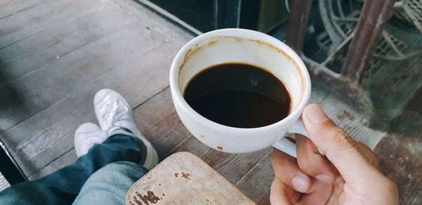 Low section of person holding coffee cup