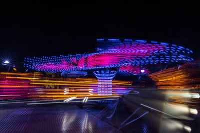 Light trails in amusement park at night