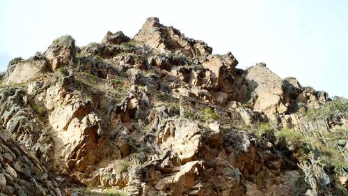 Low angle view of rocks on mountain against sky