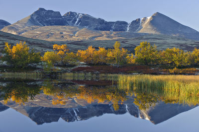 Reflection of rondslottet mountain. rondane national park, norway, europe