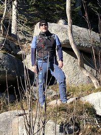 Portrait of man standing on rock in forest