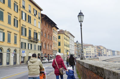 People walking on street amidst buildings in city