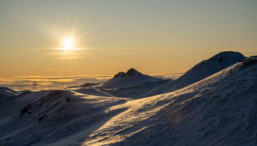 Scenic view of snowcapped mountains against sky during sunset