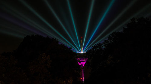 Low angle view of illuminated lights against sky at night