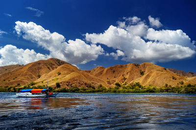 Scenic view of lake by mountains against sky