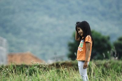 Side view of girl standing on land