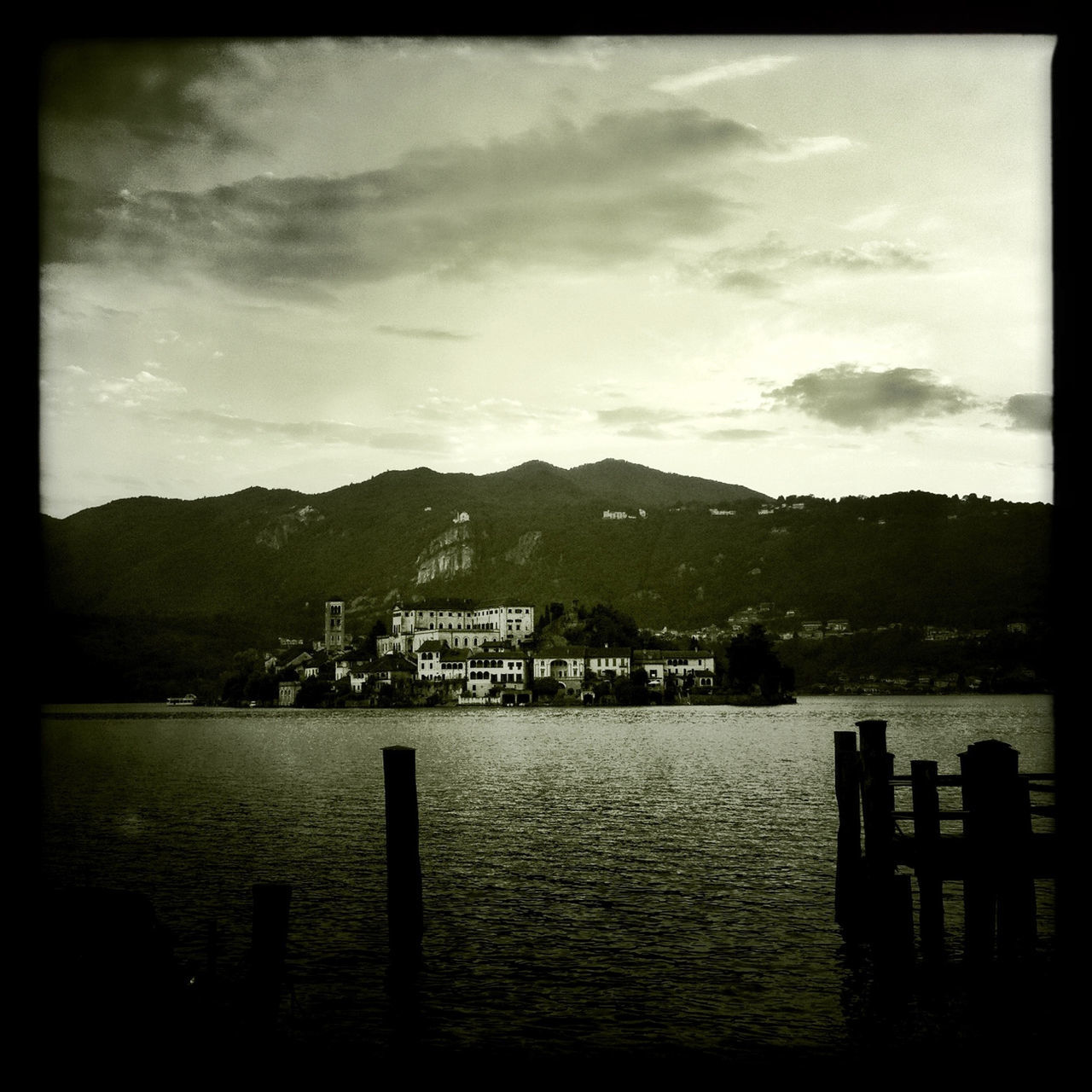 sky, water, mountain, tranquil scene, cloud - sky, tranquility, transfer print, scenics, lake, cloud, built structure, mountain range, river, auto post production filter, nature, beauty in nature, architecture, cloudy, pier, silhouette