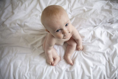 High angle view of cute baby boy sleeping on bed at home