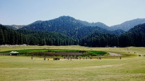 People on green landscape against sky