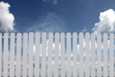 Low angle view of white fence against sky