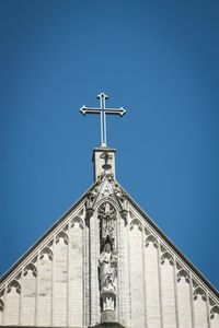 Low angle view of bell tower against blue sky