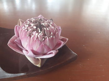 Close-up of pink rose on table