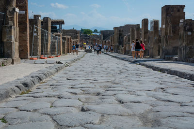 People on cobblestone street in city